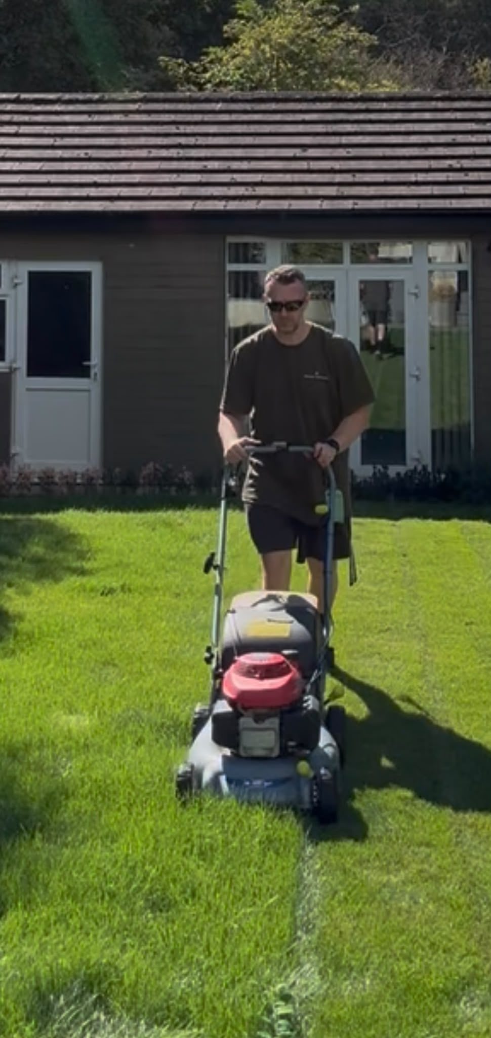Jason from JR Garden Services mowing a lawn in Watford